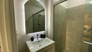 um banheiro com uma pia, um espelho e um chuveiro em Estilo Minimalista frente Arena y Parque Fundidora em Monterrey mais 18 fotografias