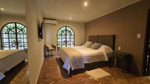Un dormitorio con dos camas y dos ventanas. en Trento Hotel Boutique, en San Salvador de Jujuy