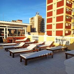a row of chaise lounges on the roof of a building at Apart Sorrento in Santa Teresita