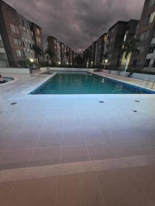 an empty swimming pool in a city at night at Luxury five in Villavicencio