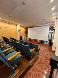 a conference room with chairs and a white screen at Apart Sorrento in Santa Teresita +45 photos