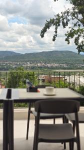 una mesa y una silla en un balcón con vistas en Trento Hotel Boutique, en San Salvador de Jujuy