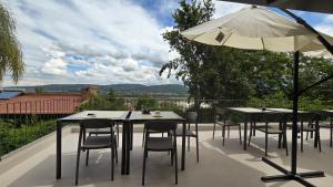 Un patio con mesas y sillas y una sombrilla. en Trento Hotel Boutique, en San Salvador de Jujuy