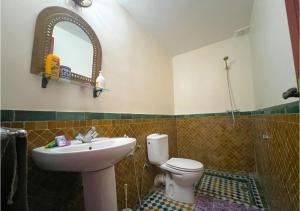 a bathroom with a sink and a toilet and a mirror at Riad Iman in Fès