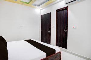 Un dormitorio con dos puertas de madera y una cama. en HOTEL O MAYUR, en Aligarh