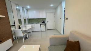 a kitchen and living room with a couch and a table at Amazon Condo, Building B, ground floor with direct pool access in Jomtien Beach