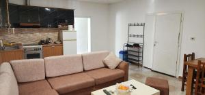 een woonkamer met een bank en een keuken bij Villa Star in Tirana +3 foto's