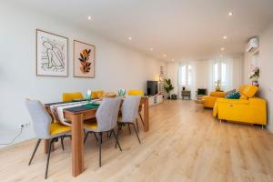 Un comedor y una sala de estar con mesa y sillas. en Casa De Mariposas Viola, en Faro