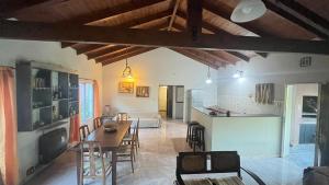 een keuken en woonkamer met een tafel en stoelen bij Casa Quinta Metac-Calle Entre Rios y Sarmiento in Villa Lía