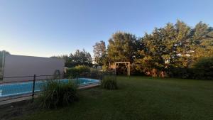 een achtertuin met een zwembad en een grasveld bij Casa Quinta Metac-Calle Entre Rios y Sarmiento in Villa Lía