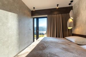 a bedroom with a large bed and a large window at Apartament Lake&Hill View w Karkonoszach z możliwym dostępem do strefy WELLNESS w kompleksie in Sosnówka