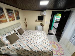 a bedroom with a bed with a comforter on it at Pousada Coração da Ilha do Mel in Ilha do Mel