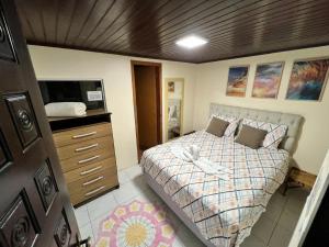 Pousada Coração da Ilha do Mel في إيلها دو ميل: غرفة نوم بسرير وخزانة وتلفزيون +64 صورة