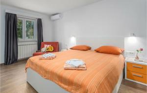 ein Schlafzimmer mit einem großen Bett mit orangefarbener Bettwäsche in der Unterkunft Stunning Home In Brecevici in Brečevići