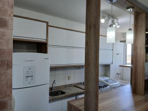 ペーニャにあるApto no Centro de Penha, a 500m do Mar RLT0262の白いキャビネットと白い冷蔵庫のあるキッチン