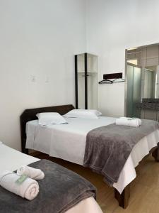 two beds in a room with towels on them at HOTEL POUSADA POR DO SOL in Pato Branco +12 photos