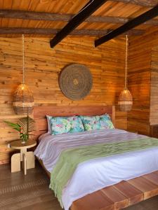a bedroom with a bed in a wooden wall at LA PERLA FINCA HOTEL in Gigante