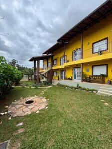 a yellow building with a yard in front of it at Vila dos Cristais - Apartamentos de Temporada in Alto Paraíso de Goiás
