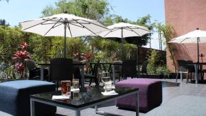 メキシコシティにあるホリデイ イン メキシコ ダリ エアポートのパティオ(パラソル付きのテーブルと椅子付)