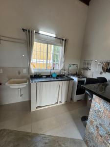 a small kitchen with a sink and a window at Vila dos Cristais - Apartamentos de Temporada in Alto Paraíso de Goiás