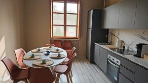 a kitchen with a table and chairs in a kitchen at beb MUFFIN in Grazzano Visconti +27 photos