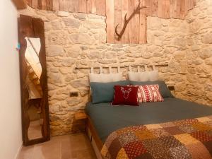 una camera da letto con un letto in un muro di pietra di Al Foér Guesthouse ad Averara