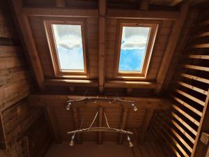 una stanza con due finestre in un edificio di legno di Al Foér Guesthouse ad Averara