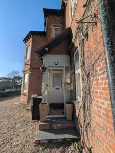 una casa di mattoni con una porta d'ingresso bianca e scale di Lakeside Oxford Hotel a Oxford
