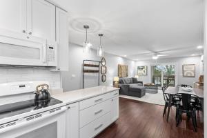a kitchen with white cabinets and a living room at 2017 Marsh Walk Villa in Summerville