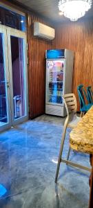 a room with a refrigerator with a table and a chair at Belo Résidence in Cap-Haïtien