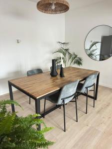 Una mesa de comedor con sillas y un espejo. en Coastal Sands Azores, en Ribeira Grande