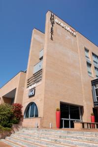 a large brick building with steps in front of it at Executive Hotel in Forlì