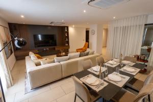 ein Wohnzimmer mit Sofa, Tisch und Stühlen in der Unterkunft KAYs APARTMENT in Accra