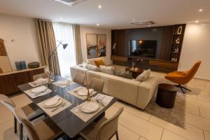 ein Wohnzimmer mit Sofa, Tisch und Stühlen in der Unterkunft KAYs APARTMENT in Accra + 2 Fotos