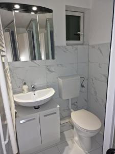 a white bathroom with a toilet and a sink at La Fontana in Langelsheim +80 photos