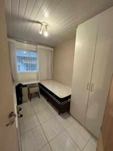 een kleine kamer met een bed en een raam bij República Descolada! Exclusiva para mulheres! in Florianópolis