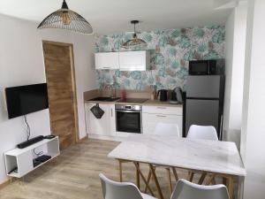 a kitchen with a dining table and a refrigerator at L'instant Doubs in Baume-les-Dames
