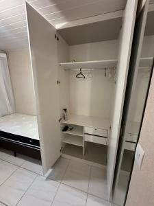 een kleine witte kamer met een bed en een bureau bij República Descolada! Exclusiva para mulheres! in Florianópolis