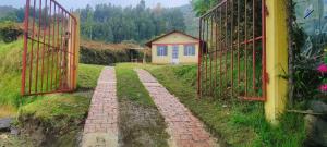 Cabaña El Refugio في دويتاما: بوابة مع ممر من الطوب يؤدي إلى منزل