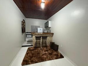 a kitchen with two bar stools and a counter at Residencial Filhos da Lua in Lençóis