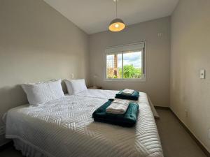 a bedroom with a large bed with two towels on it at Vila dos Cristais - Apartamentos de Temporada in Alto Paraíso de Goiás