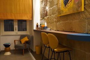 eine Bar mit zwei Stühlen und einem Tresen mit gelben Kissen in der Unterkunft Rooms Around in Neapel