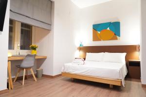 ein Schlafzimmer mit einem Bett, einem Schreibtisch und einem Stuhl in der Unterkunft Rooms Around in Neapel