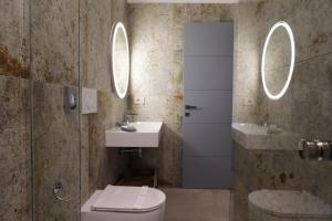 ein Badezimmer mit Toilette, Waschbecken und Spiegel in der Unterkunft Rooms Around in Neapel