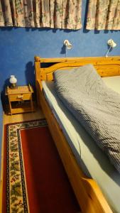ein Schlafzimmer mit einem Holzbett und einem daneben stehenden Nachttisch in der Unterkunft The Blue house apartment in Andøya