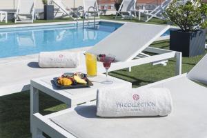 a table with a plate of food and a glass of juice at NH Collection Lisboa Liberdade in Lisbon