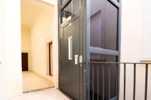 una puerta negra en un edificio con balcón en Dragonetti Luxury House, en LʼAquila