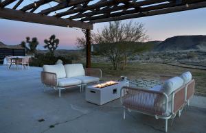 drie stoelen en een vuurplaats op een patio bij The Giddyup in Pioneertown