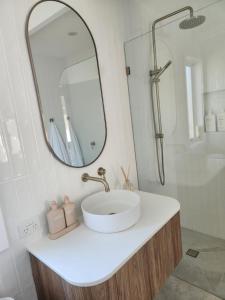 a white bathroom with a sink and a mirror at Beach Bound-Jervis Bay in Vincentia +10 photos
