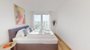 a white room with a bed and a window at HEIMATEL - Ferienhaus im Alpenblick in Primisweiler